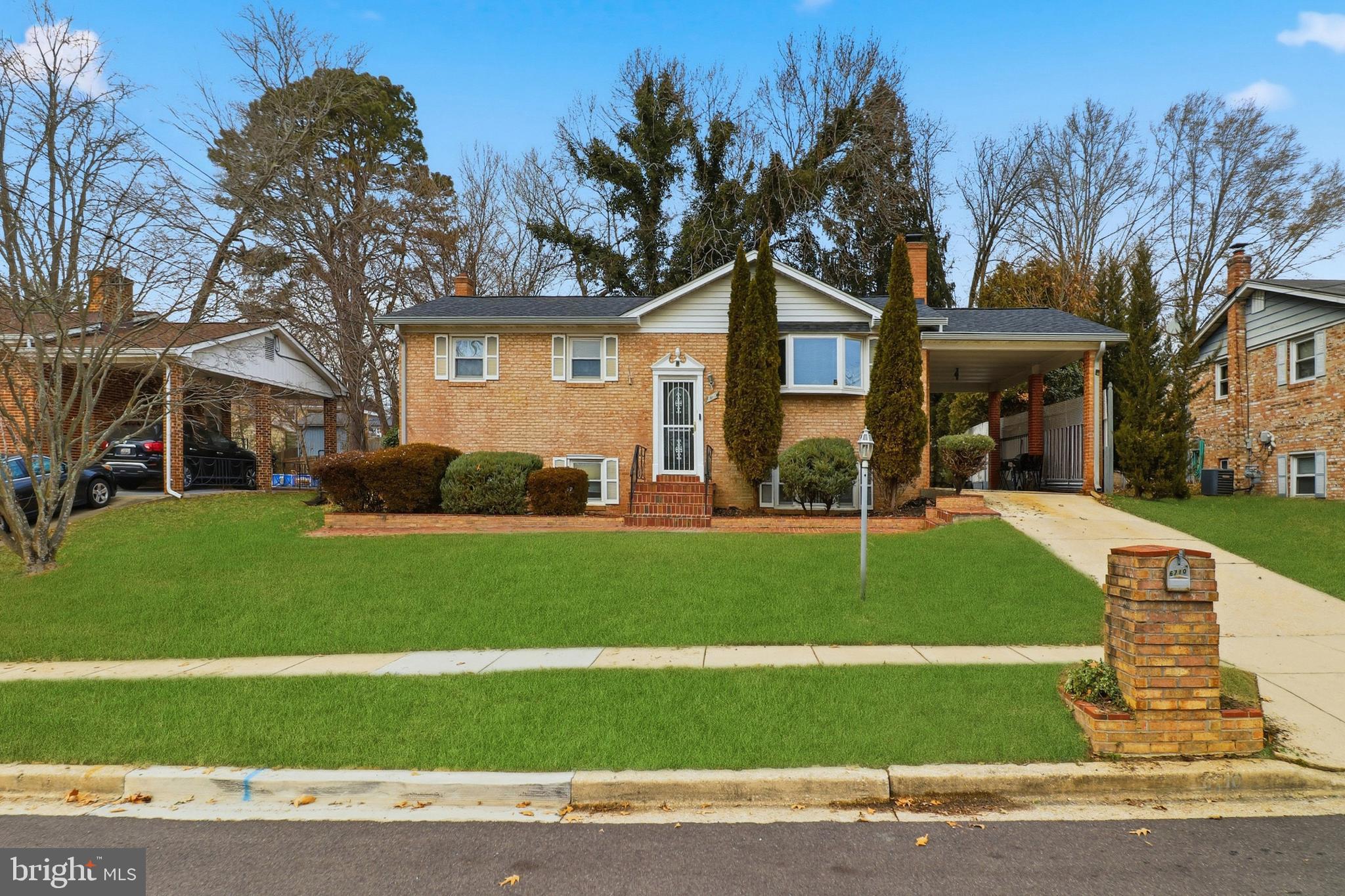 6710 Eilerson Street Clinton, MD 20735 - Photo 2 of 58 a front view of a house with a garden and trees