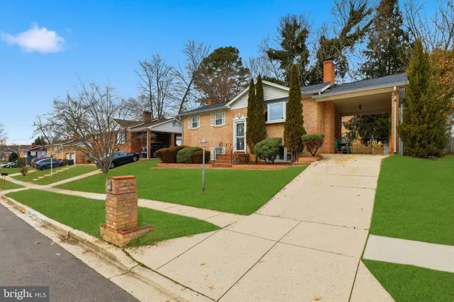a front view of a house with a yard and trees