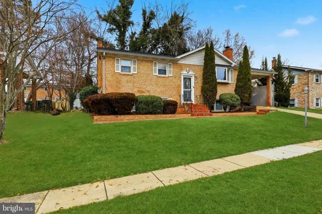 a front view of a house with a garden and yard