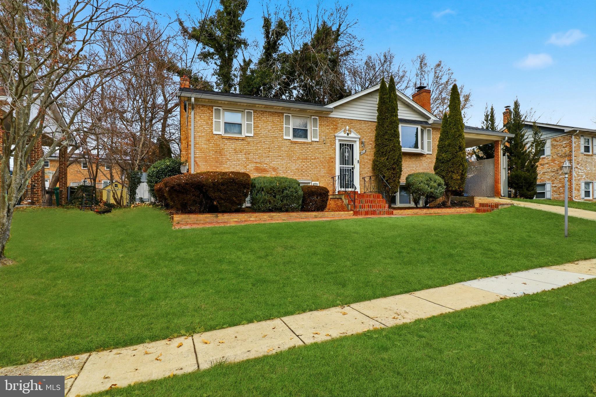 6710 Eilerson Street Clinton, MD 20735 - Photo 4 of 58 a front view of a house with a garden and yard
