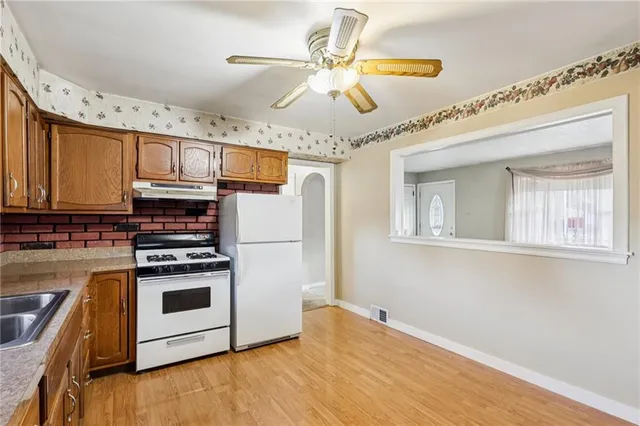 a kitchen with stainless steel appliances granite countertop a stove a sink and a refrigerator
