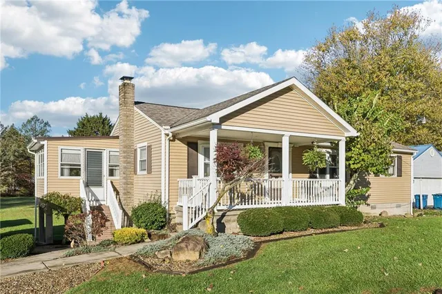 a front view of a house with a yard and potted plants