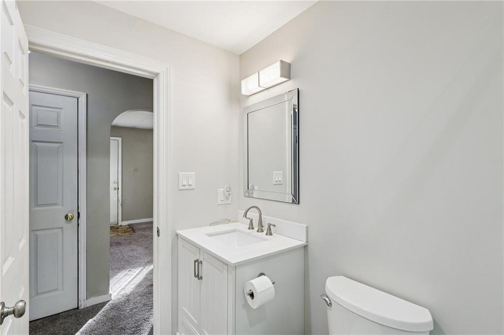 2422 Ridgewood Court New Castle, PA 16101 - Photo 22 of 50 a bathroom with a toilet a sink a mirror and vanity