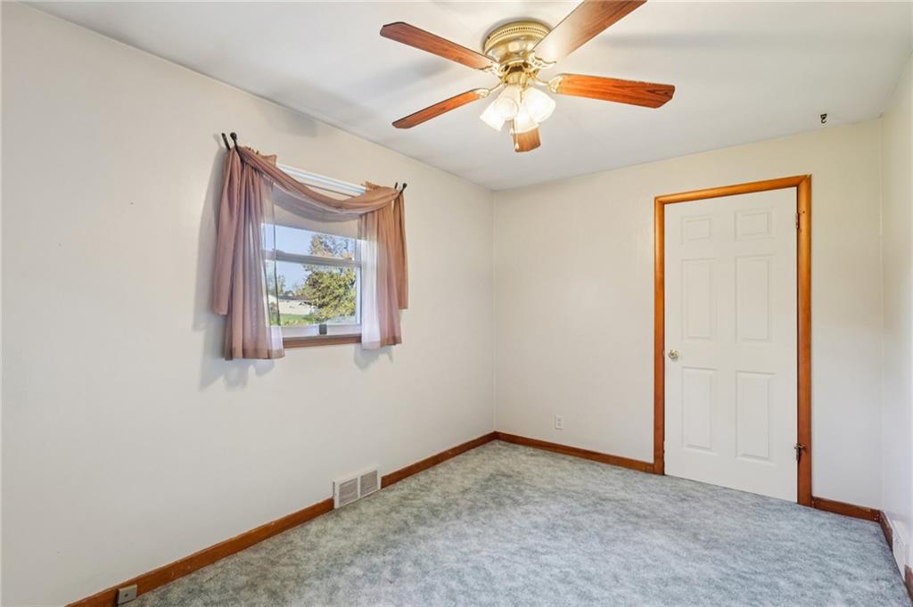 2422 Ridgewood Court New Castle, PA 16101 - Photo 27 of 50 an empty room with a chandelier fan and windows