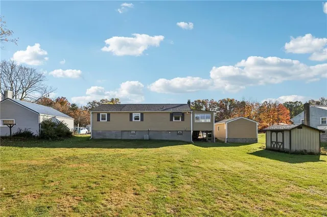 a view of a house with a big yard and large tree