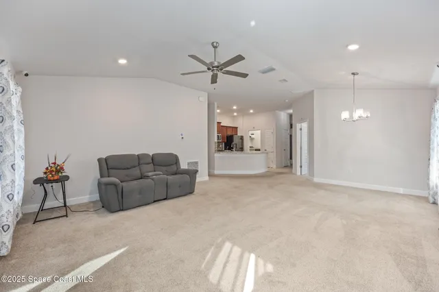 a living room with furniture and a ceiling fan