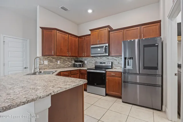 a kitchen with stainless steel appliances granite countertop a refrigerator stove and sink