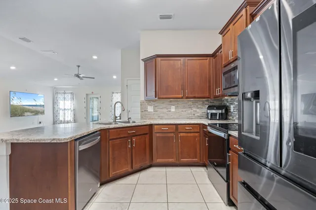 a kitchen with stainless steel appliances granite countertop a sink stove and refrigerator