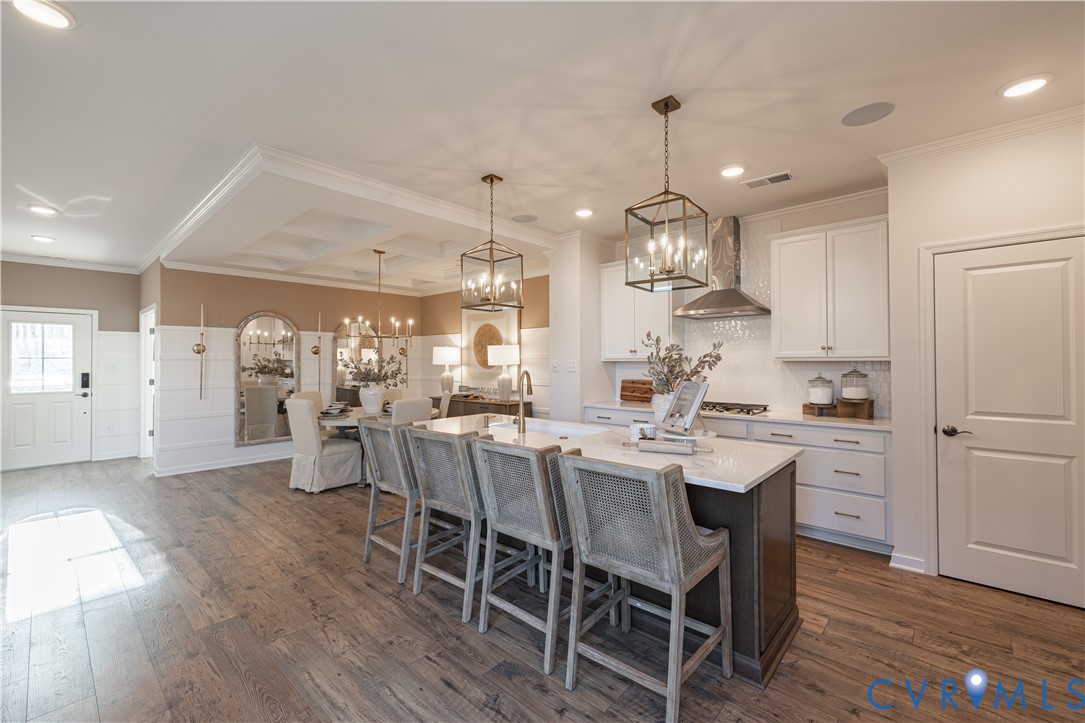 6609 Mayland Rdg Lane; Moseley, VA 23120 - Photo 6 of 20 a kitchen with kitchen island a dining table and wooden floor