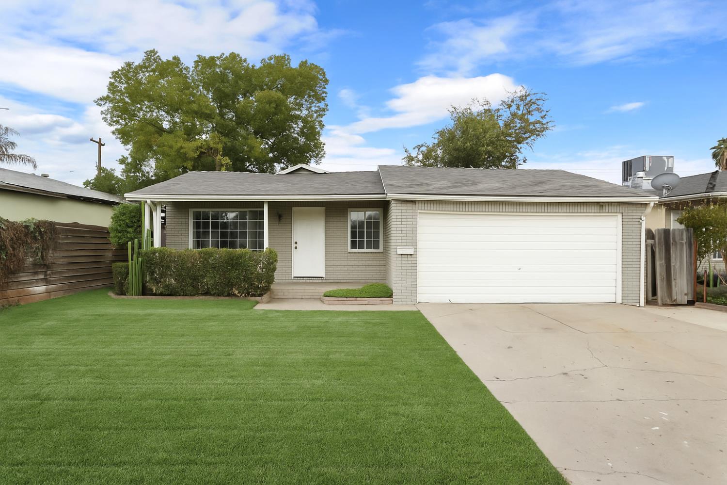 a front view of a house with a garden and yard