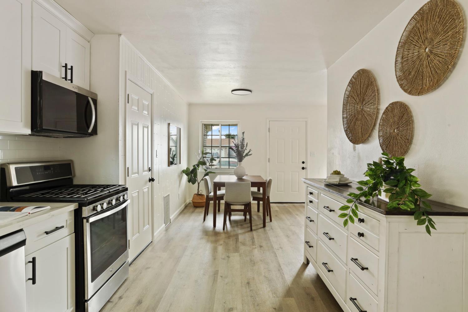 1636 South School Street Lodi, CA 95240 - Photo 18 of 33 a kitchen with stainless steel appliances granite countertop a stove a sink dishwasher and a fireplace with wooden floor