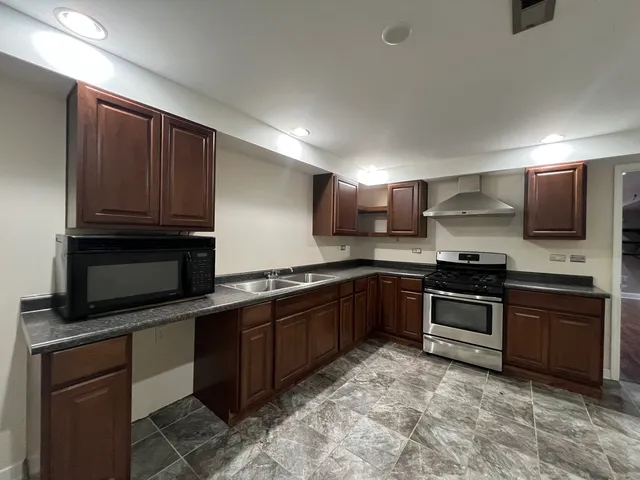 a kitchen with stainless steel appliances granite countertop a stove microwave and sink