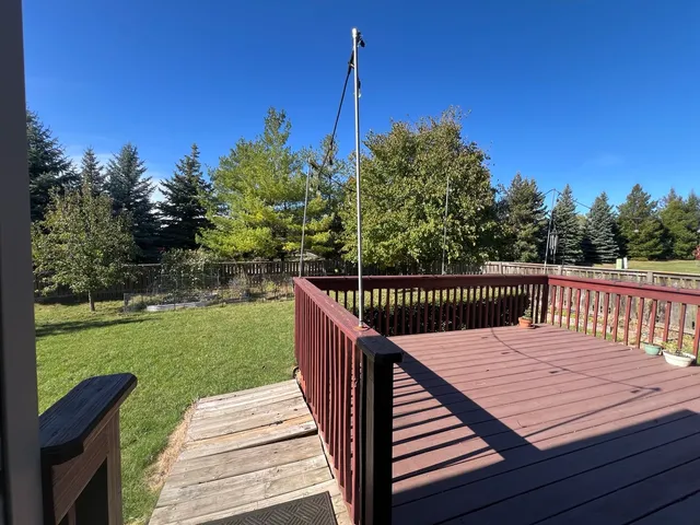 a view of a wooden deck and a yard with swimming pool