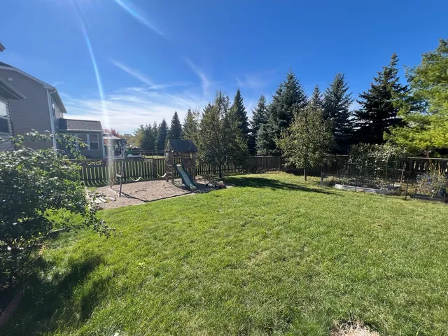 a view of a backyard with a garden and entertaining space