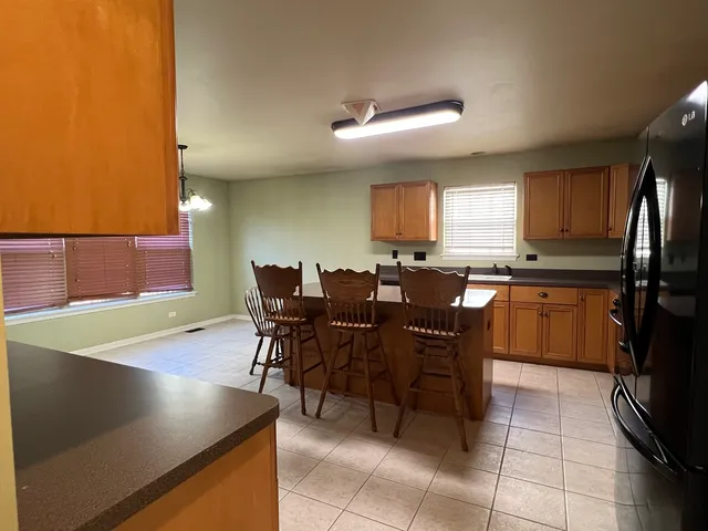 a kitchen with a cabinets a dining table and chairs