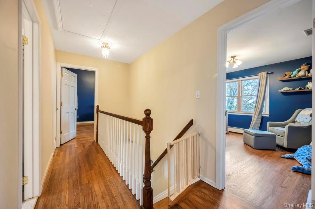 39 Bevin Road Northport, NY 11768 - Photo 23 of 44 Hallway featuring an upstairs landing, wood finished floors, and baseboard heating