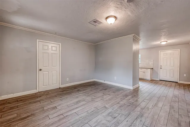 a view of an empty room with wooden floor
