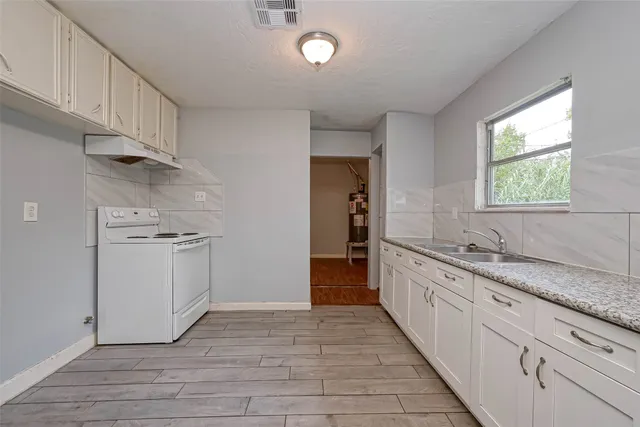 a kitchen with granite countertop white cabinets and white appliances