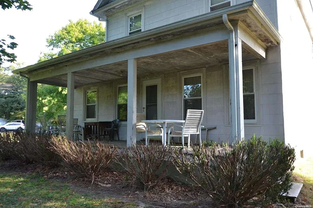 a view of house with backyard and outdoor seating