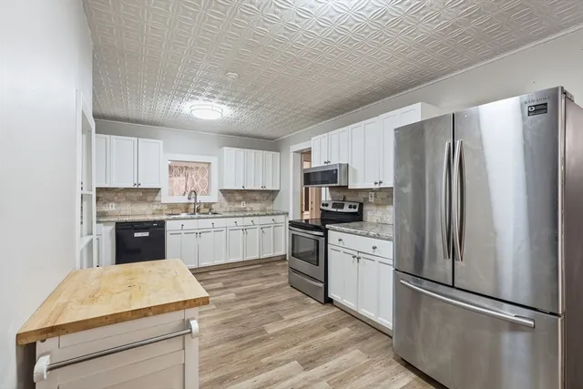 a kitchen with stainless steel appliances a refrigerator sink and microwave