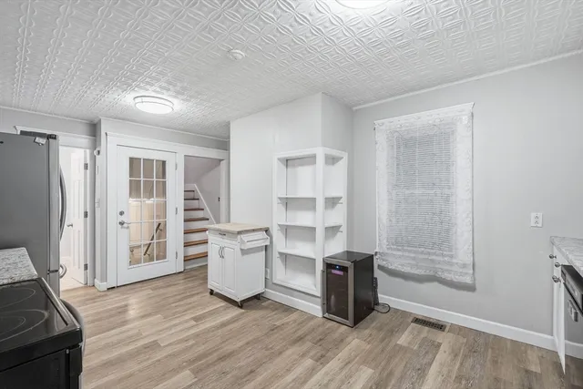 an empty room with wooden floor cabinet and windows