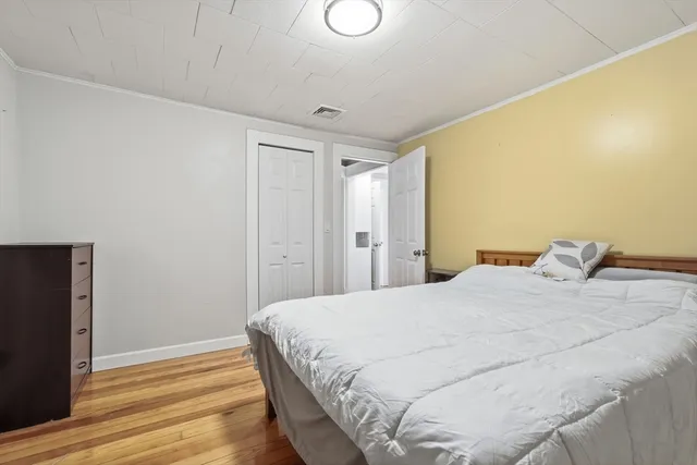a bedroom with a bed and wooden floor