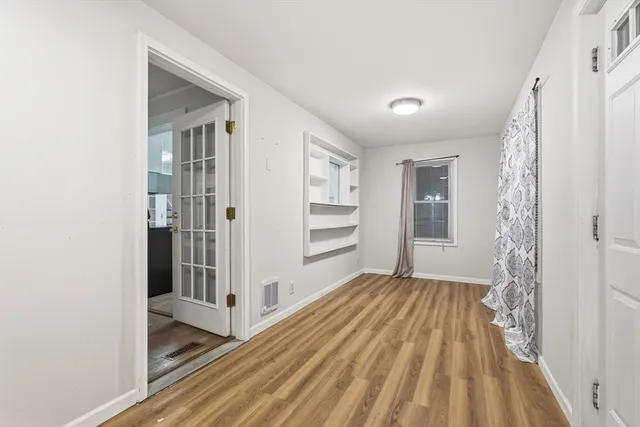 a view of a hallway with wooden floor and entryway