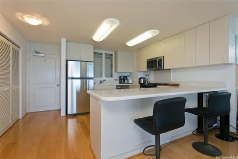 a kitchen with stainless steel appliances granite countertop a stove a refrigerator a sink a stove a dining table and chairs