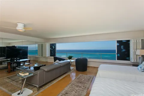 a living room with furniture a flat screen tv and kitchen view