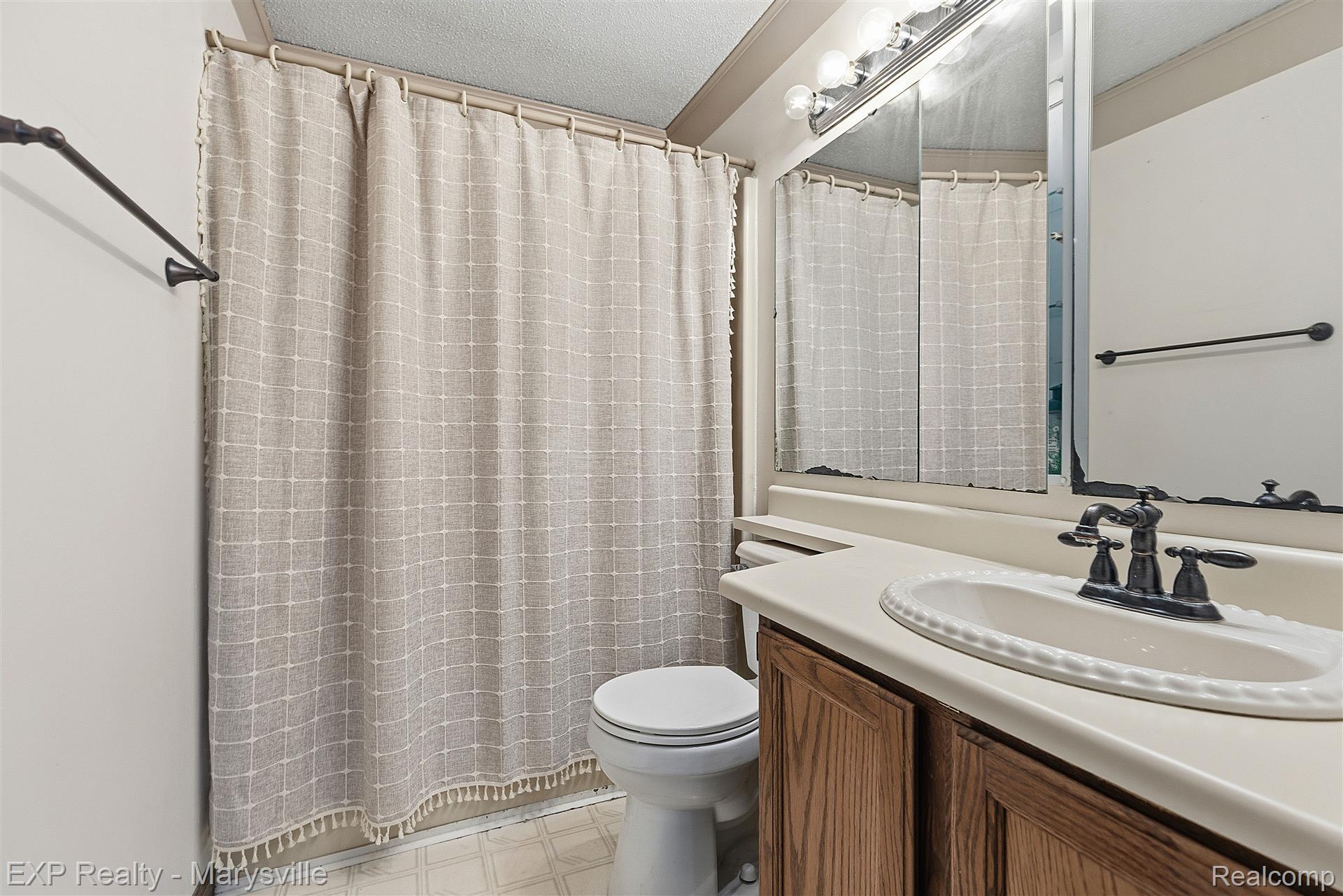12265 Hough Road Memphis, MI 48041 - Photo 22 of 41 Full bath featuring curtained shower, vanity, light flooring, and a textured ceiling