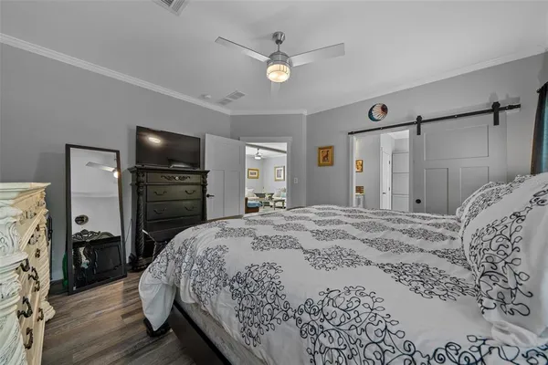 a spacious bedroom with a bed and a flat screen tv