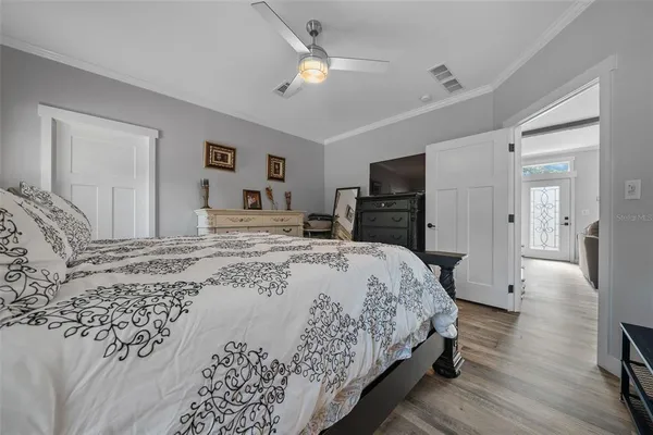 a bedroom with a large bed a flat tv screen and large dresser