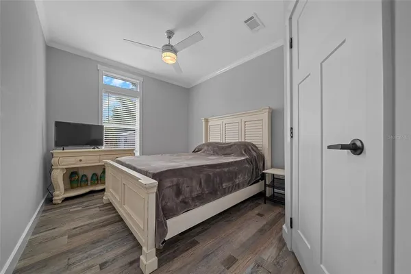 a view of a bedroom with a bed and a flat screen tv