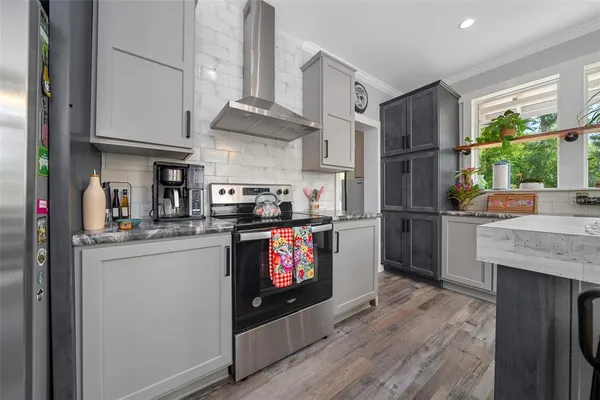 a kitchen with stainless steel appliances granite countertop a refrigerator a stove a sink and a microwave