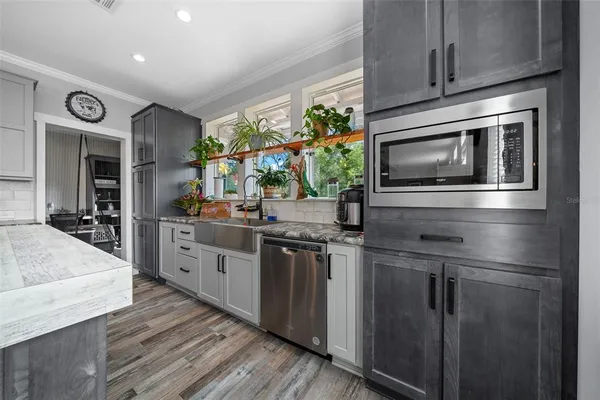 a kitchen with stainless steel appliances kitchen island granite countertop a stove a sink and a microwave