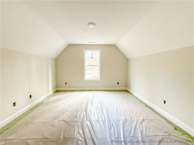 a backyard of a house with large trees and wooden fence
