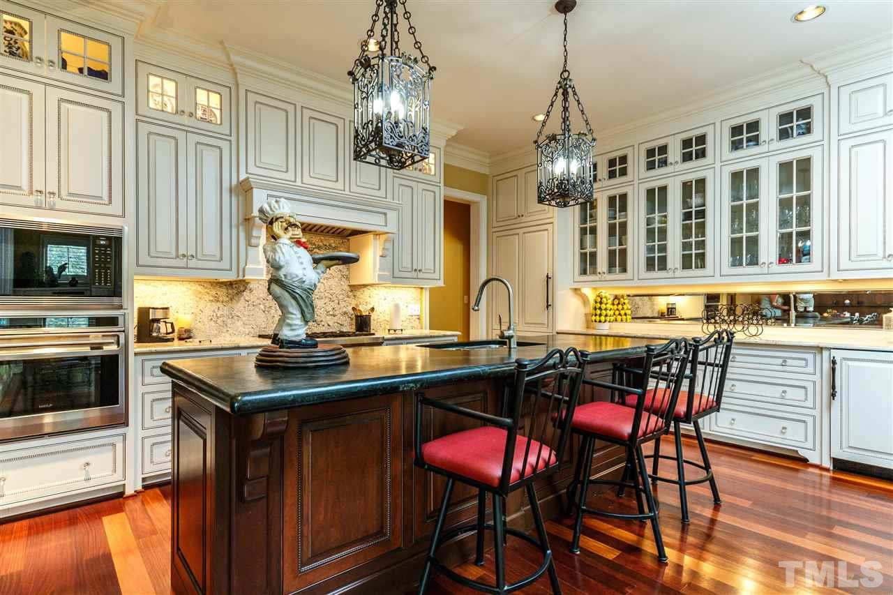3721 Rolston Drive Raleigh, NC 27609 - Photo 8 of 30 a kitchen with stainless steel appliances granite countertop a stove top oven a sink dishwasher a dining table and chairs with wooden floor
