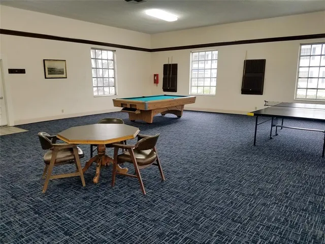 a room with pool table and windows
