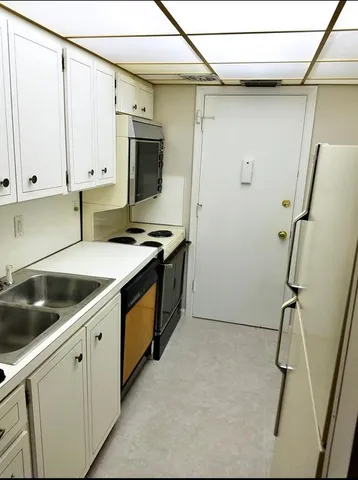 a kitchen that has a sink a stove and cabinets