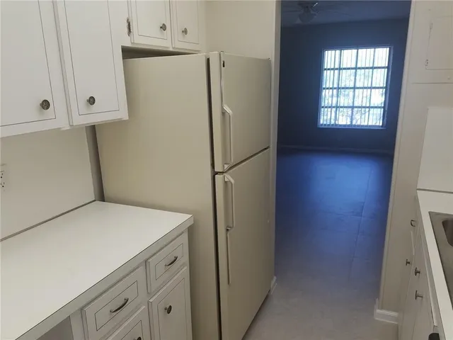 a white refrigerator freezer and a stove sitting inside of a kitchen