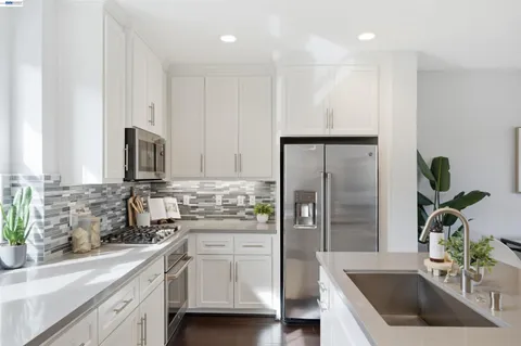 a kitchen with a sink a counter top space and living room view