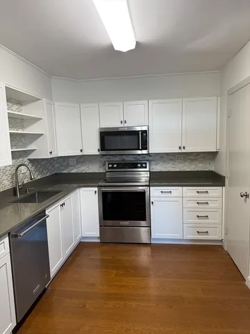 a kitchen with granite countertop white cabinets and a sink