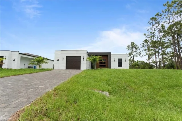 a front view of a house with a yard and a garage