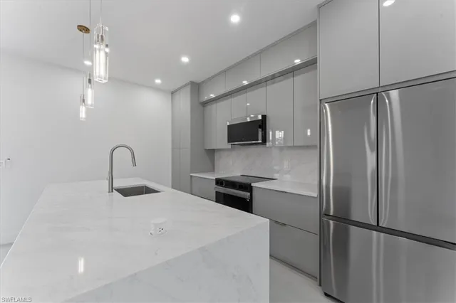 a kitchen with stainless steel appliances a refrigerator sink and cabinets