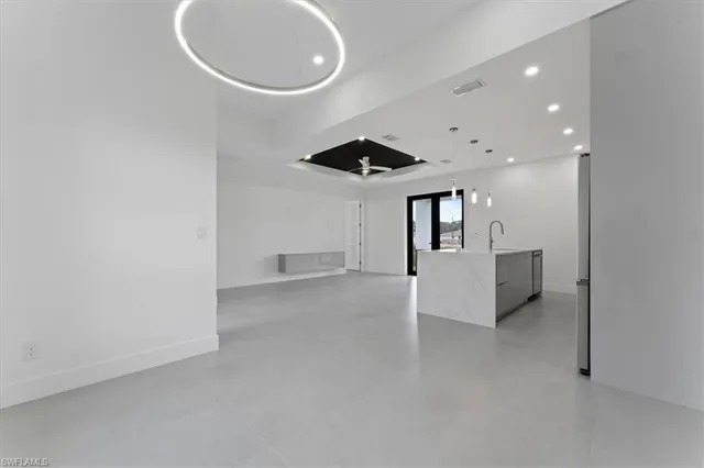 an empty room with windows and ceiling fan