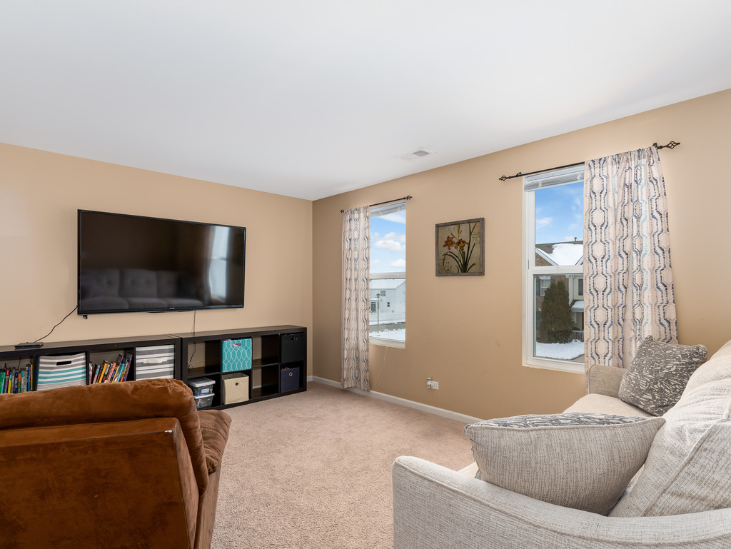 1765 Sebastian Road Woodstock, IL 60098 - Photo 11 of 25 a living room with furniture and a flat screen tv