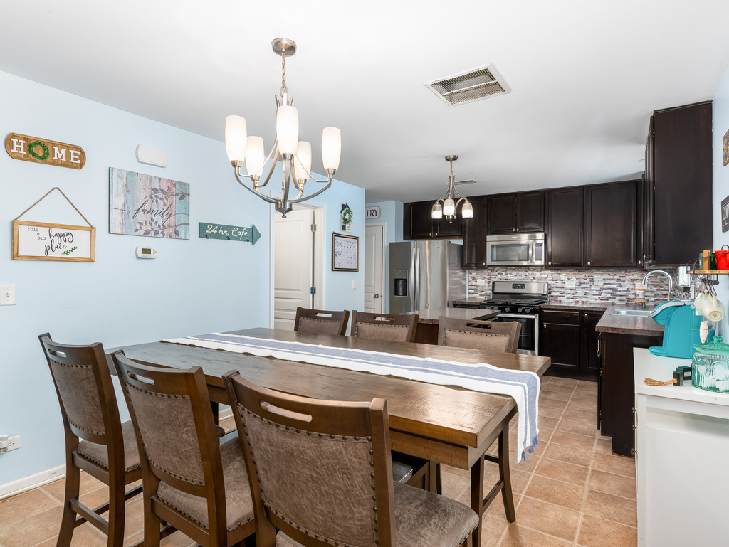 1765 Sebastian Road Woodstock, IL 60098 - Photo 6 of 25 a kitchen with a dining table chairs stainless steel appliances and cabinets