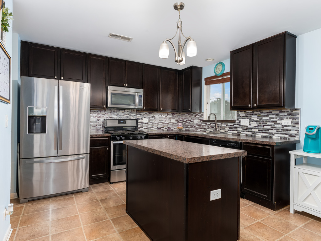 1765 Sebastian Road Woodstock, IL 60098 - Photo 8 of 25 a kitchen with stainless steel appliances granite countertop a sink stove and refrigerator