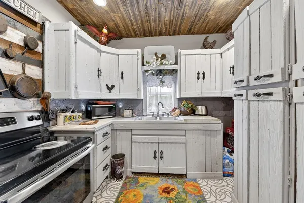 a kitchen with stainless steel appliances a stove a sink and cabinets