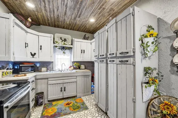 a kitchen with stainless steel appliances a stove a chimney a sink and cabinets